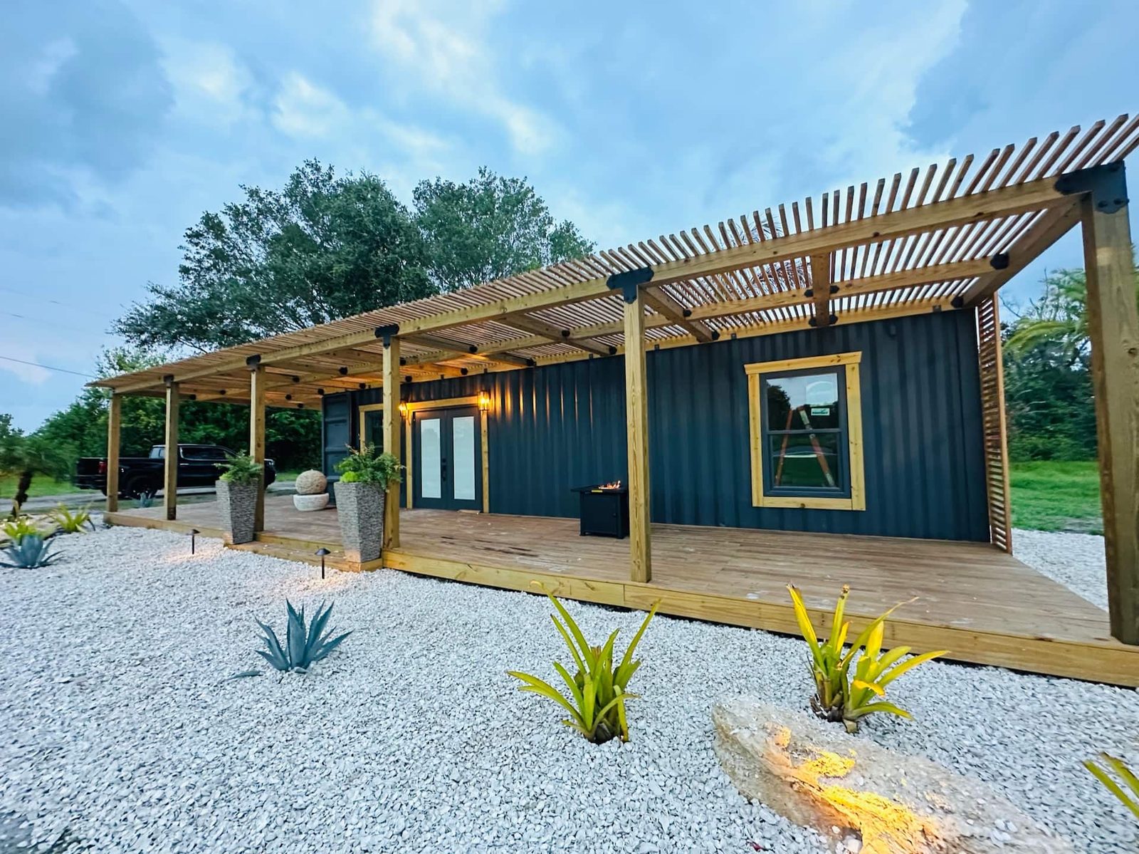 TSUR Homes container home exterior with covered deck and landscaping