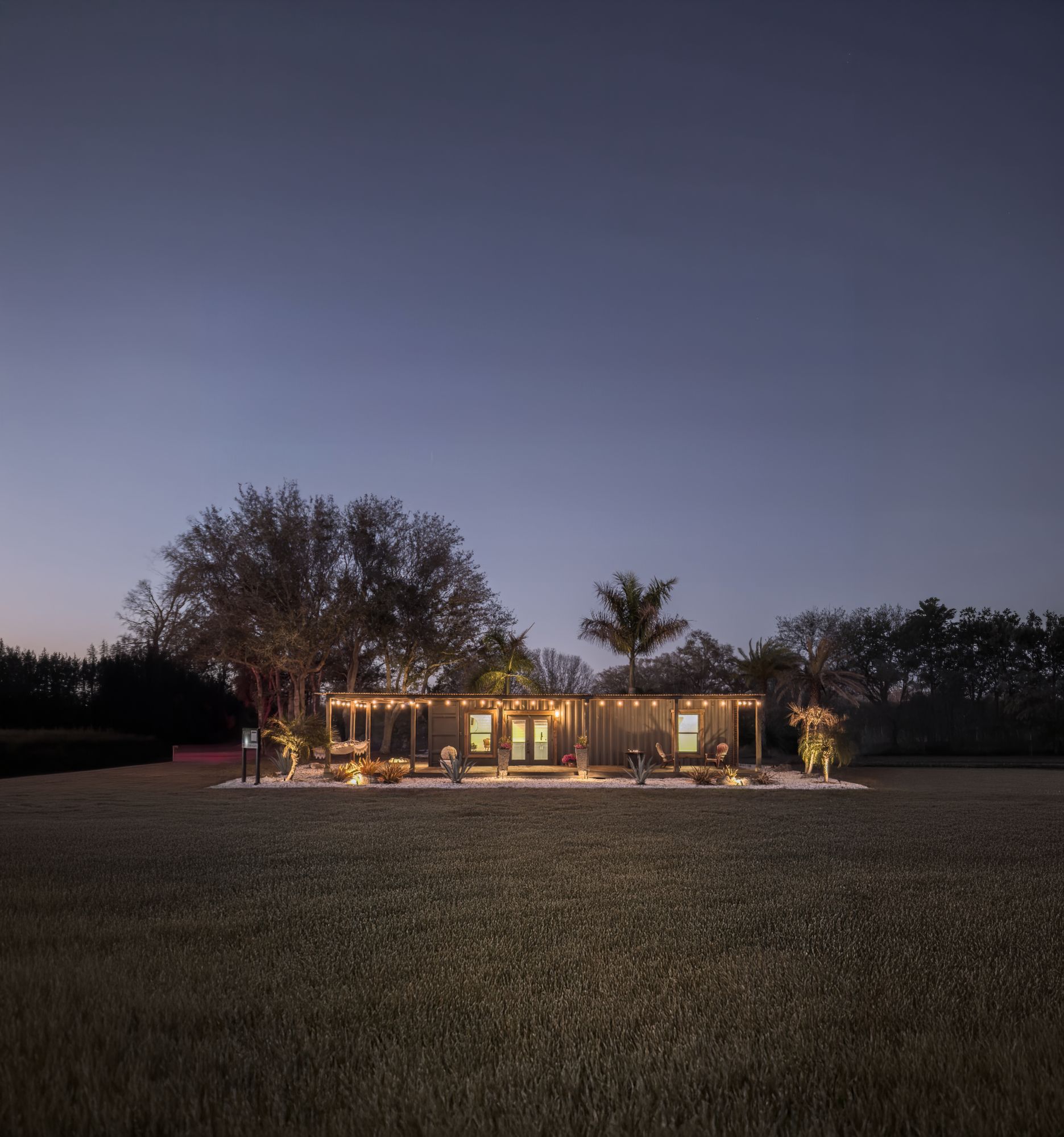 TSUR Homes at night with warm interior glow and string lights